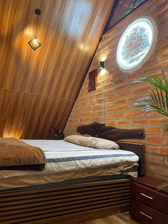 a bedroom with a bed and a brick wall at Killa Glamping in Sangolquí