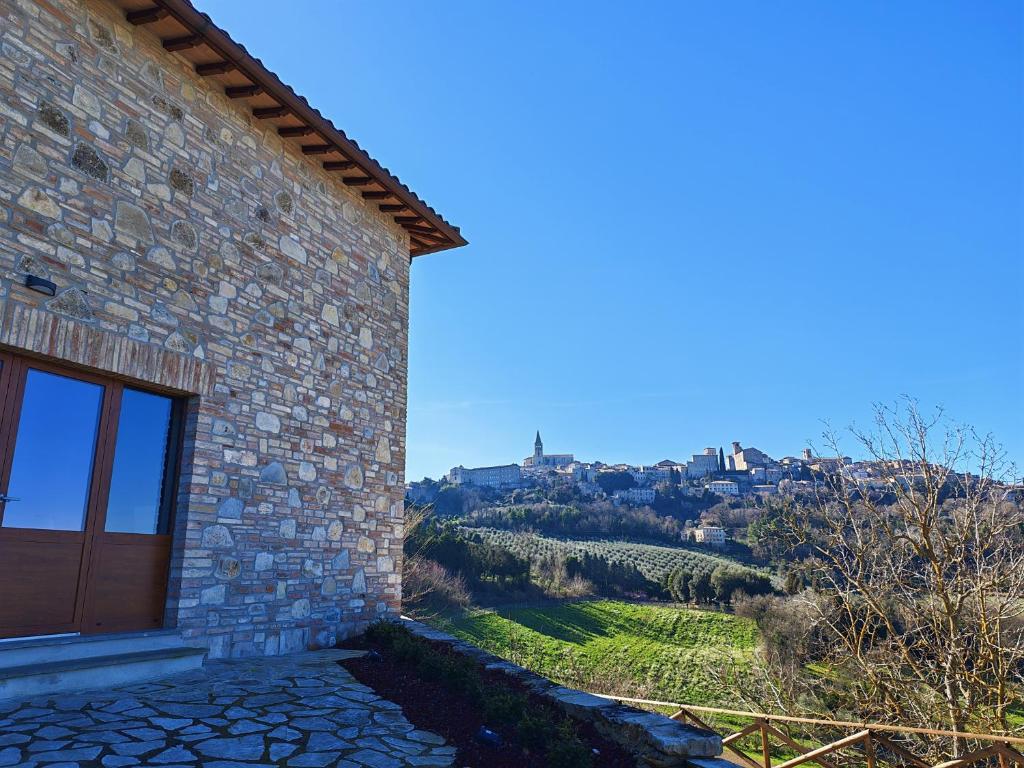 a stone house with a view of a vineyard at Il Casale del Priore in Todi