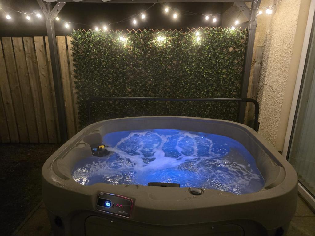 a jacuzzi tub with a person in it with lights at North Coast Nook in Portrush