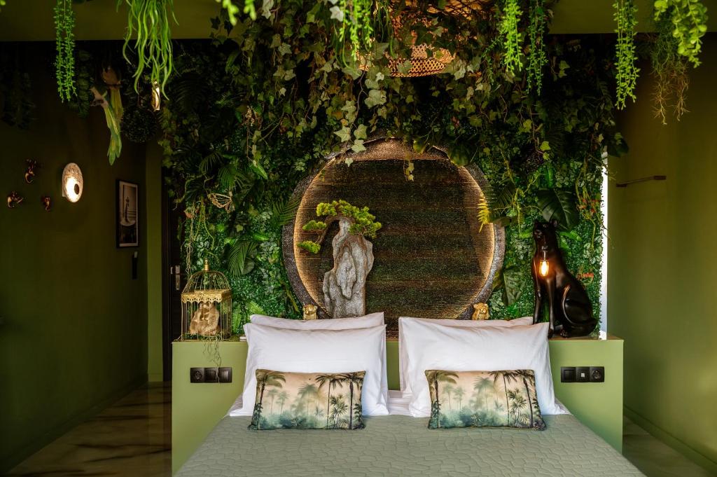 a bedroom with a bed with plants on the wall at Fairytale Athens - Luxury Suites in Athens