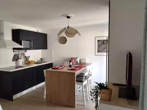 a kitchen with a island in the middle of a room at Studio proche océan dans résidence 3 étoiles avec piscine et parking privé in Mimizan-Plage