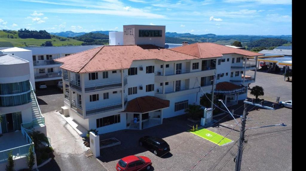 ein großes weißes Gebäude mit rotem Dach in der Unterkunft Hotel Maichel in Erval Velho