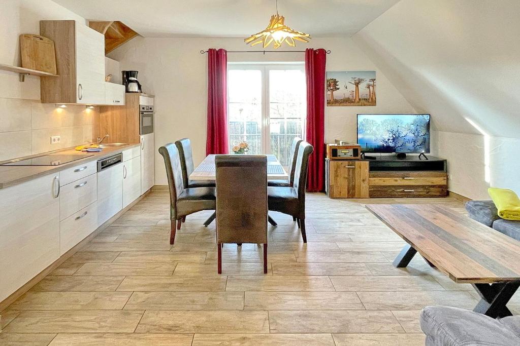 a kitchen and dining room with a table and a television at Luftschloss Baum 6 in Burg