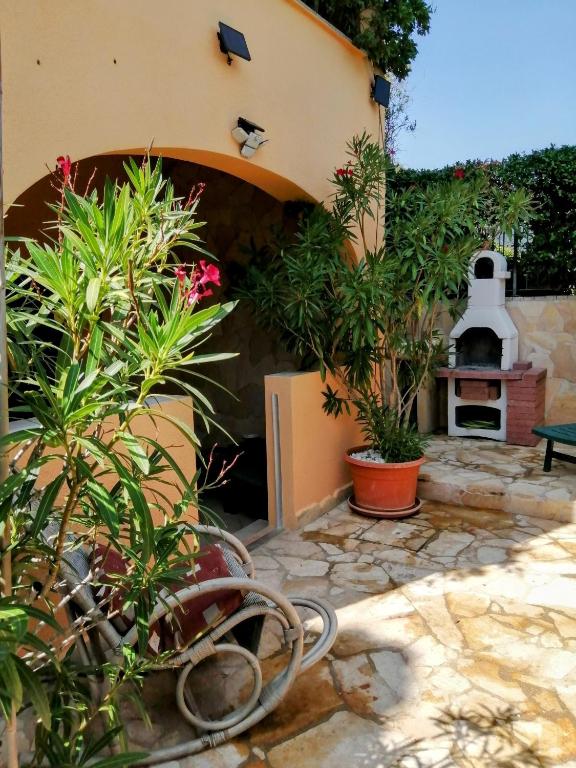 a patio with plants and a pizza oven at Grazioso appartamento con tutti confort in Lu Lioni