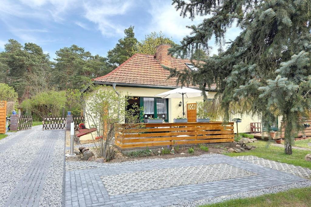 a house with a wooden fence in front of it at Zach Waldglück in Groß Klessow