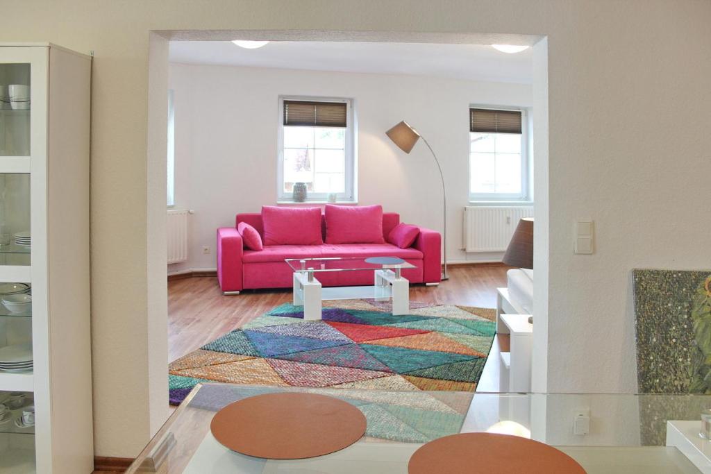 a living room with a pink couch and a rug at Lilie in Lübbenau