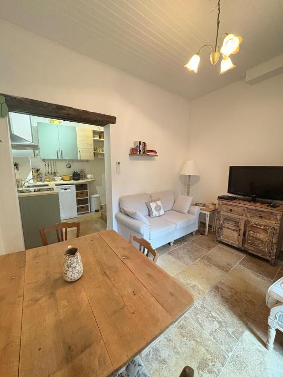 a living room with a table and a couch at Chez Fabienne Maison Fontvieille in Fontvieille
