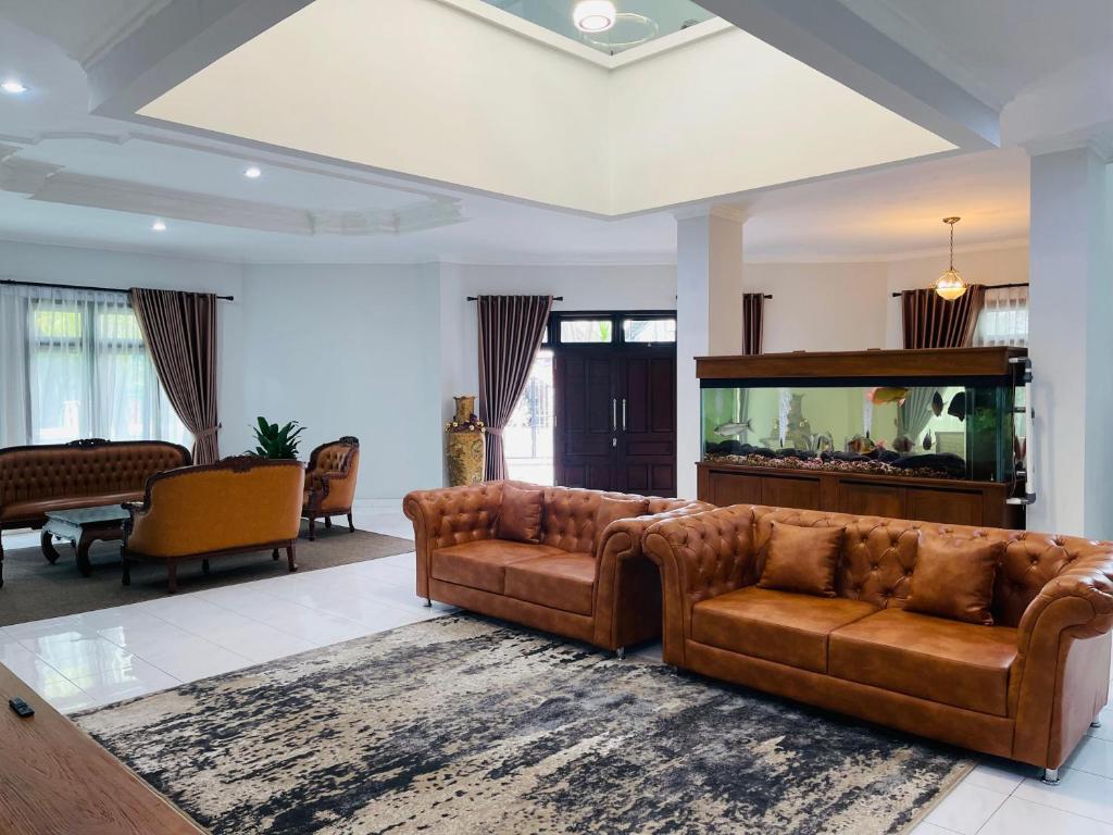 a living room with a couch and a fish tank at Ornella Villa in Yogyakarta