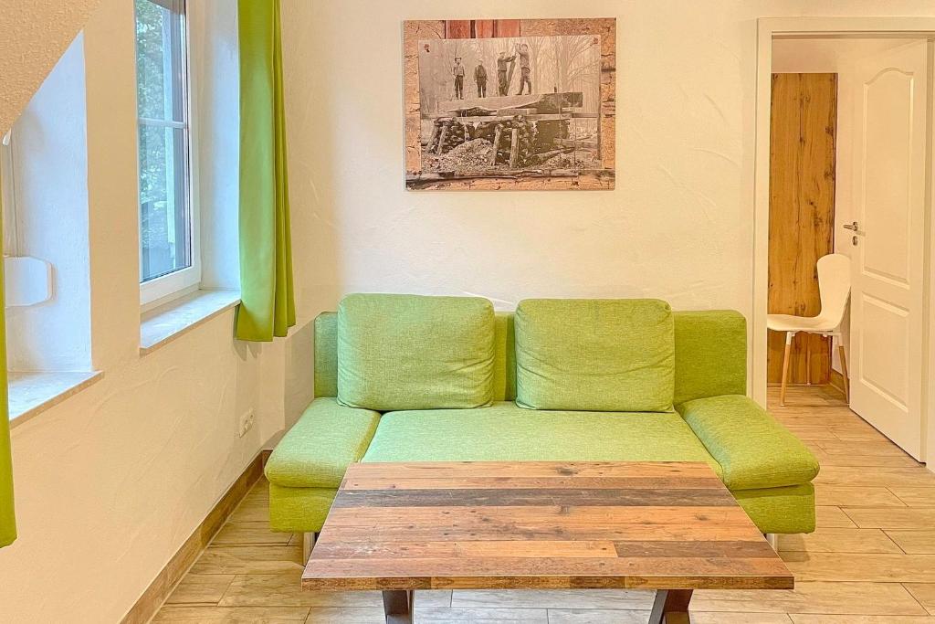 a living room with a green couch and a table at Spreeblick Baum 5 in Burg