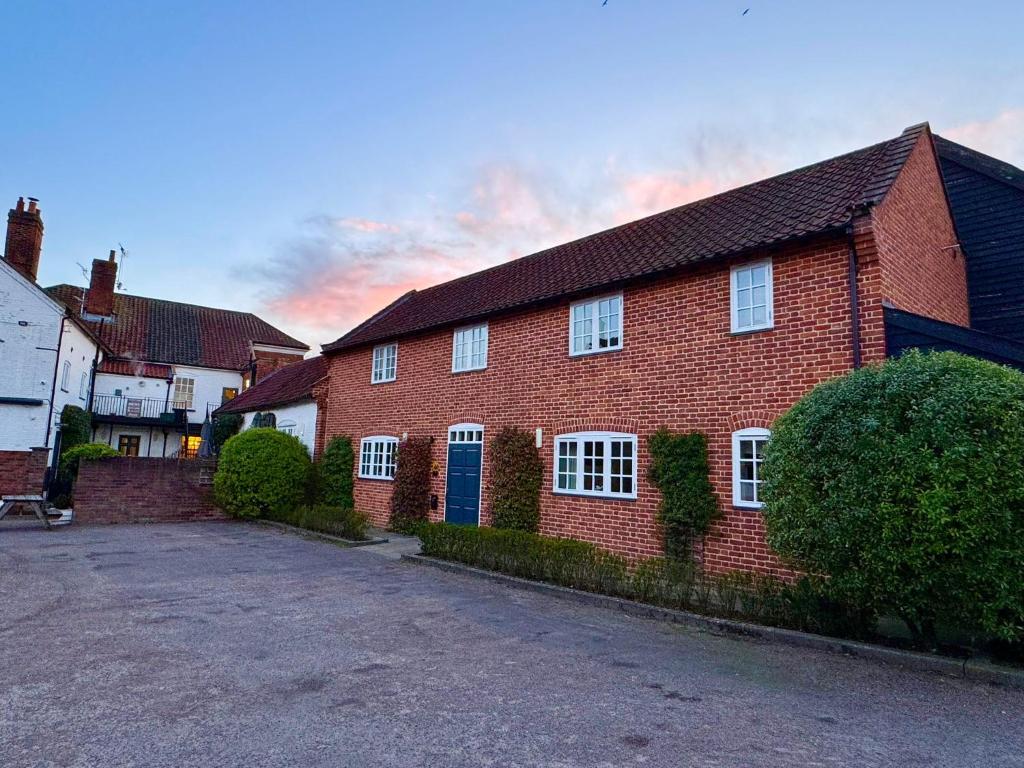 a red brick house with a blue door at The Loddon Swan in Loddon