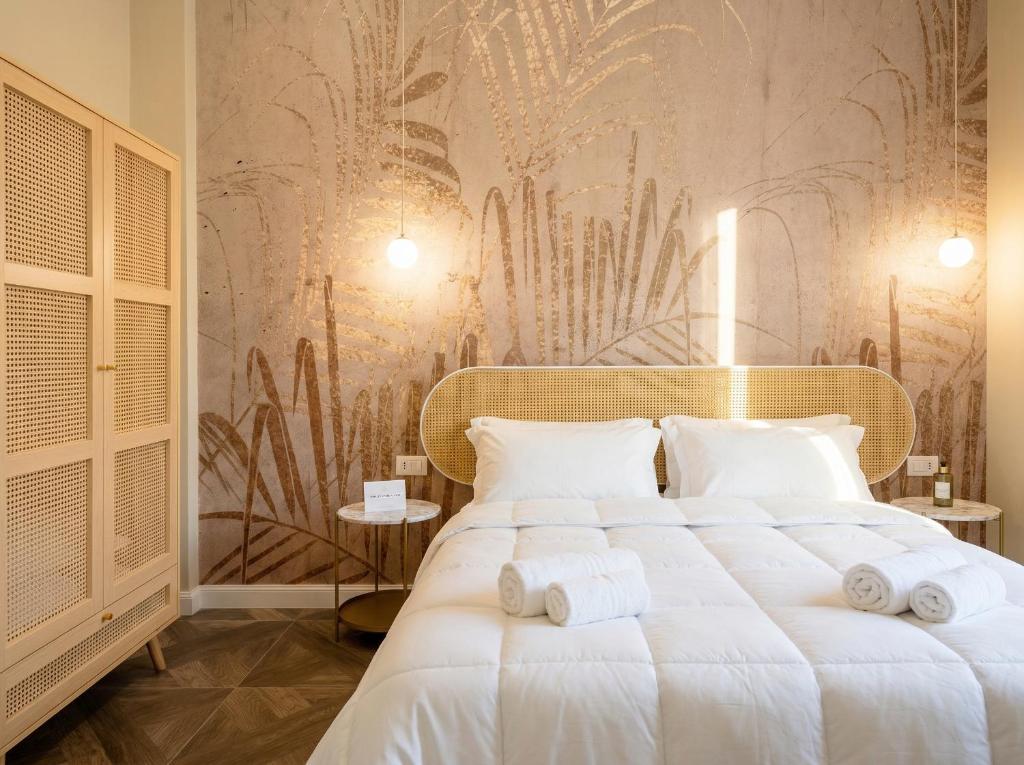 a bedroom with a large white bed with towels on it at Sfazion - Central Apartment in Bari