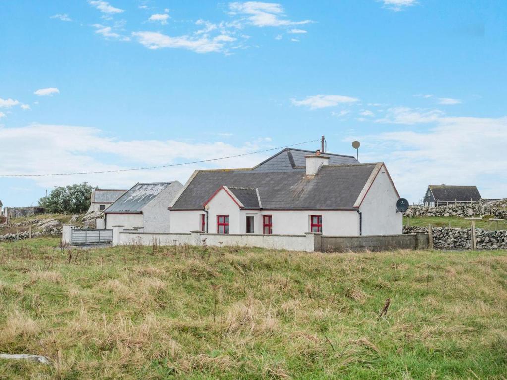 a white house on a hill in a field at 3 Bed in Roundstone oc-i234 in Callow