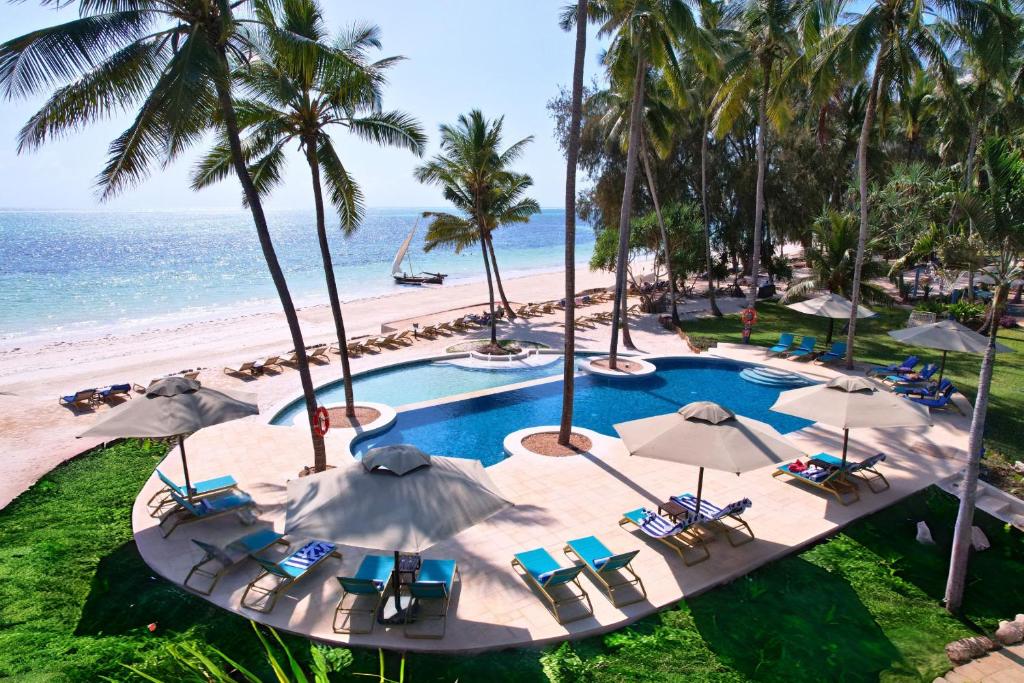 a pool with chairs and umbrellas on a beach at Bluebay Beach Resort & Spa in Kiwengwa