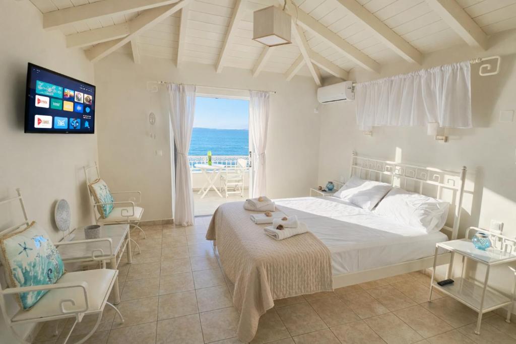 a bedroom with a bed and a view of the ocean at Ammos Boutique Rooms-Seafront Stay in Elafonisos in Elafonisos