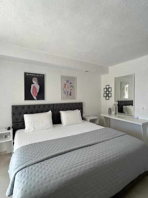 a white bedroom with a large bed with white pillows at Fiosal Apartments 2 in Skiathos
