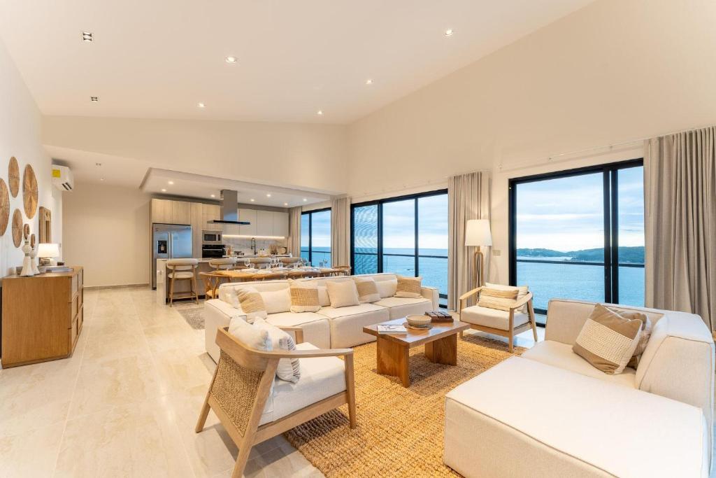 a living room with white furniture and large windows at 3075 - Paradise Cove 3A Cacalutilla in Tangolunda