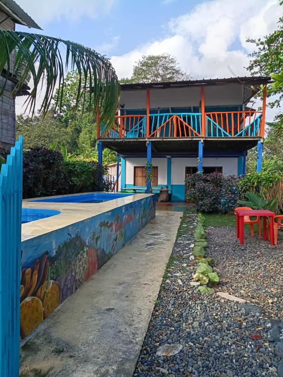 a house with a deck on the side of it at Casa hostal playa coral in Capurganá