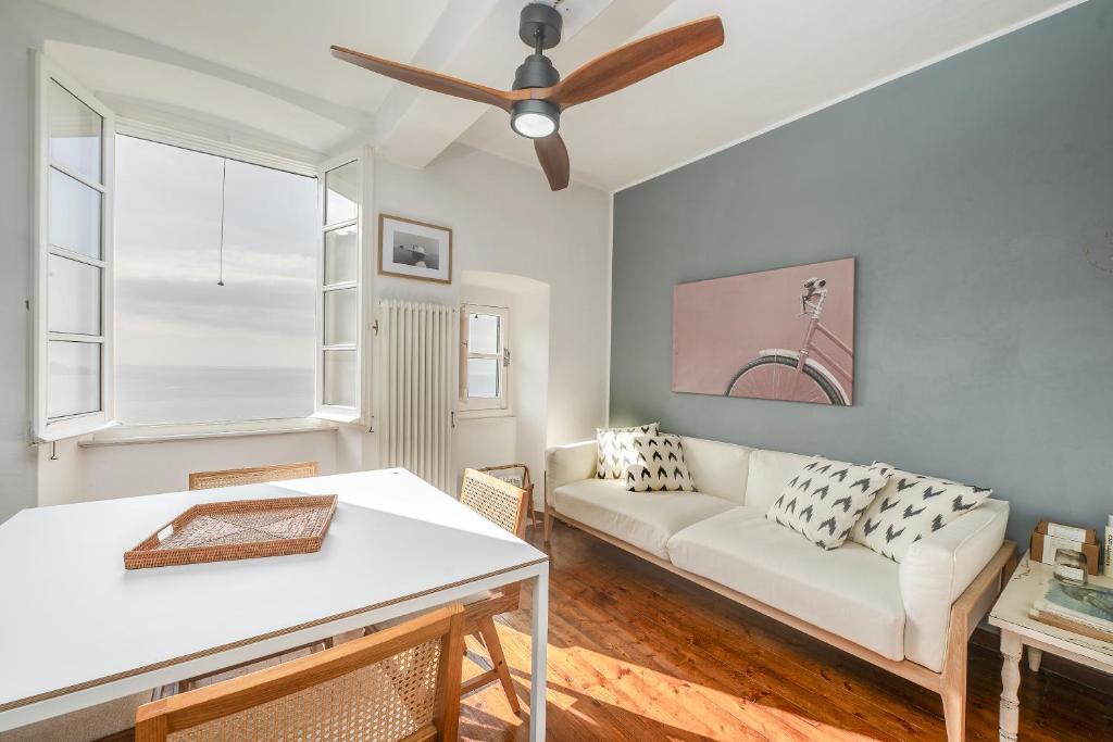 a living room with a white couch and a ceiling fan at Casa Anita - Storia & Mare in Zoagli