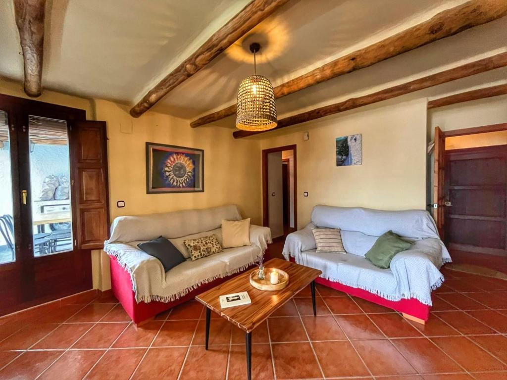 a living room with two couches and a table at Capileira Luz de Sierra in Capileira