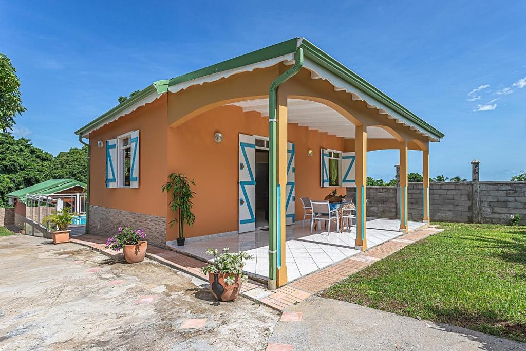 a small house with a porch and a patio at Gîte Dalina Sainte-Rose in Sainte-Rose