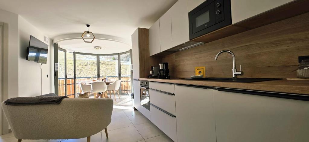 a kitchen with a sink and a counter with a chair at Les Chalets d'Offaz - Centre Abondance - Alp'in C in Abondance