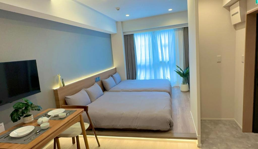 a bedroom with a bed and a table and a tv at AKATSUKI HOTEL Ueno JR山手線鶯谷駅まで徒歩3分 成田空港直行 新宿渋谷直通 in Tokyo