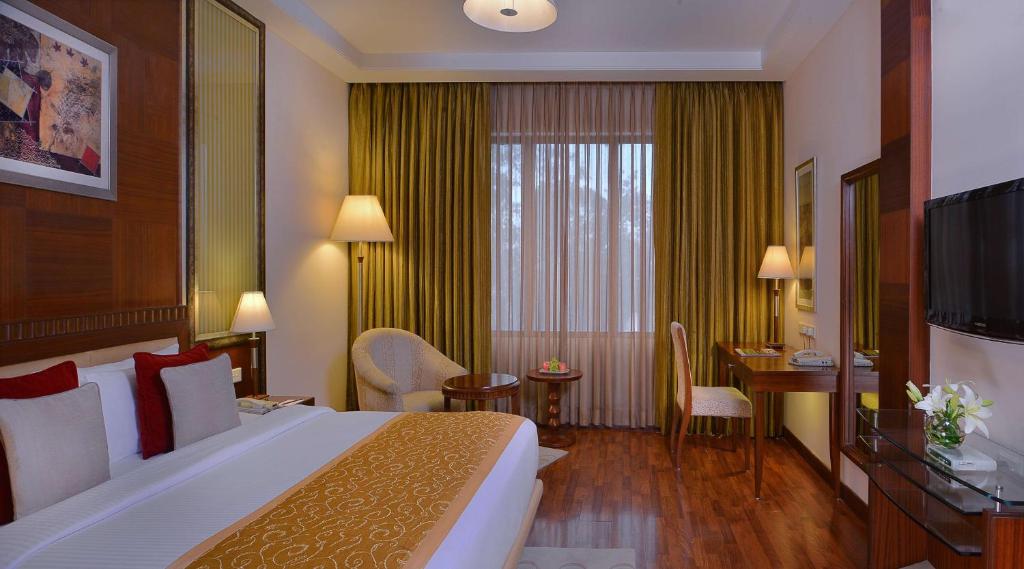 a hotel room with a large bed and a desk at Best Western Plus Jalandhar in Jalandhar