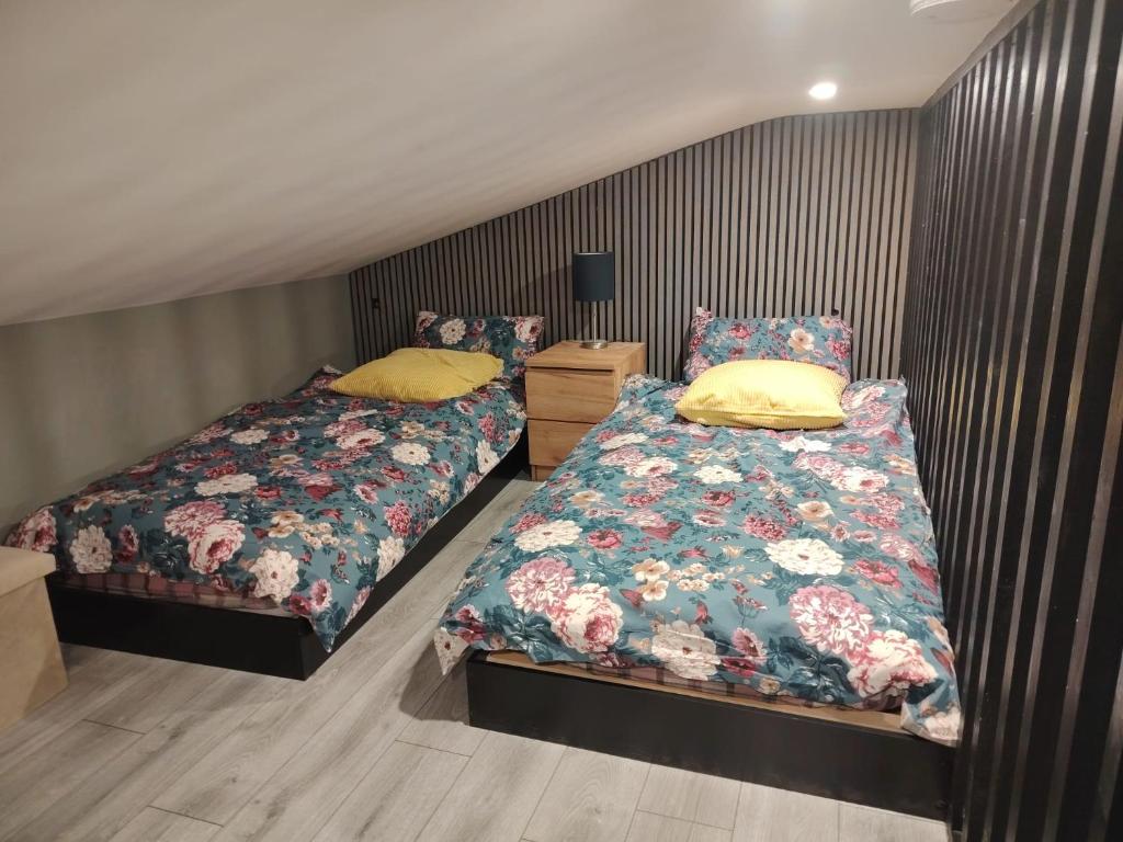 two beds sitting next to each other in a bedroom at Tramway Apartment in Blessington