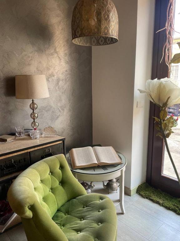 a living room with a green chair and a table at DormidaNoi B&B in Civitanova Marche