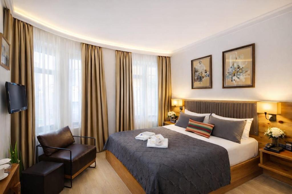 ein Hotelzimmer mit einem Bett und einem Stuhl in der Unterkunft Double DD Hotel in Istanbul