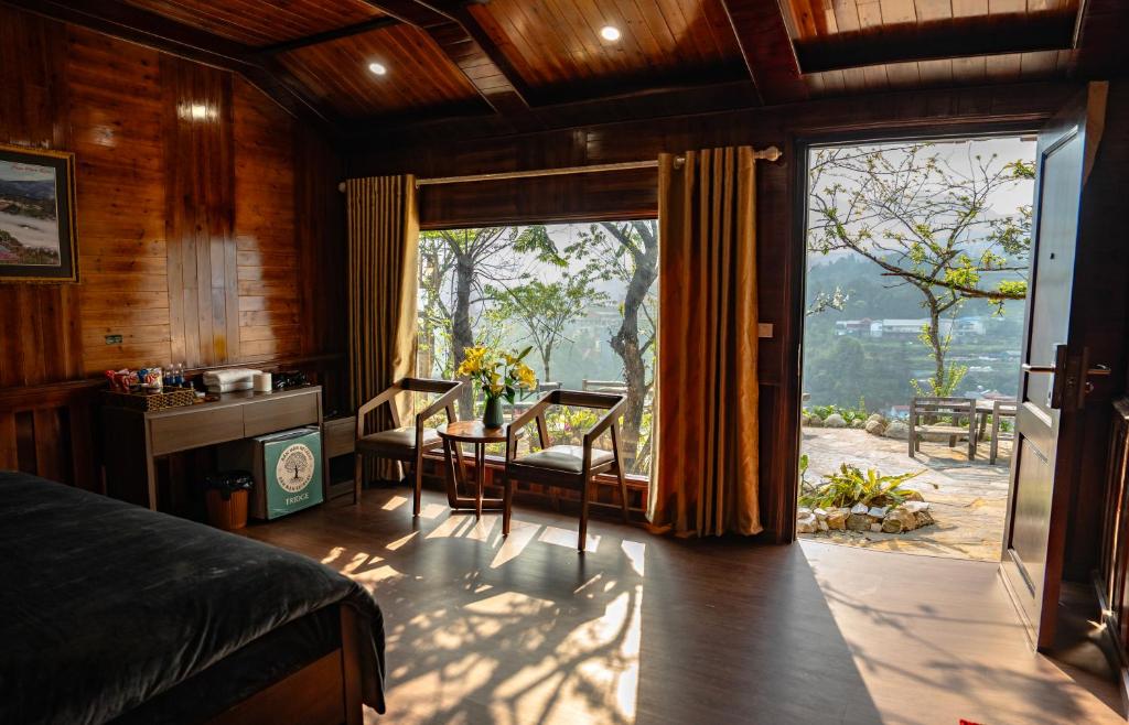 a bedroom with a bed and a large window at Bản Mận Retreat in Sapa