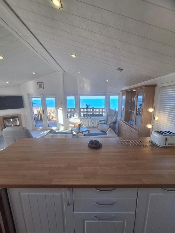 a kitchen and living room with a view of the ocean at Bayview Luxury Lodge in Cockburnspath