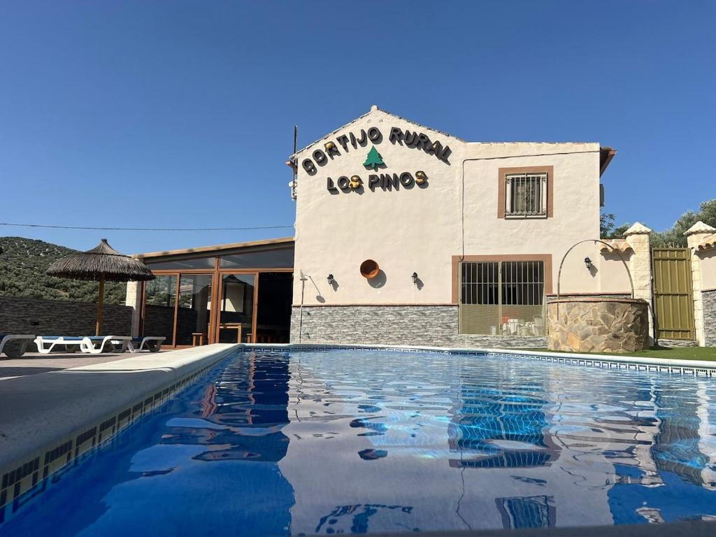 a swimming pool in front of a building at Cortijo rural Los Pinos in Villanueva de Algaidas