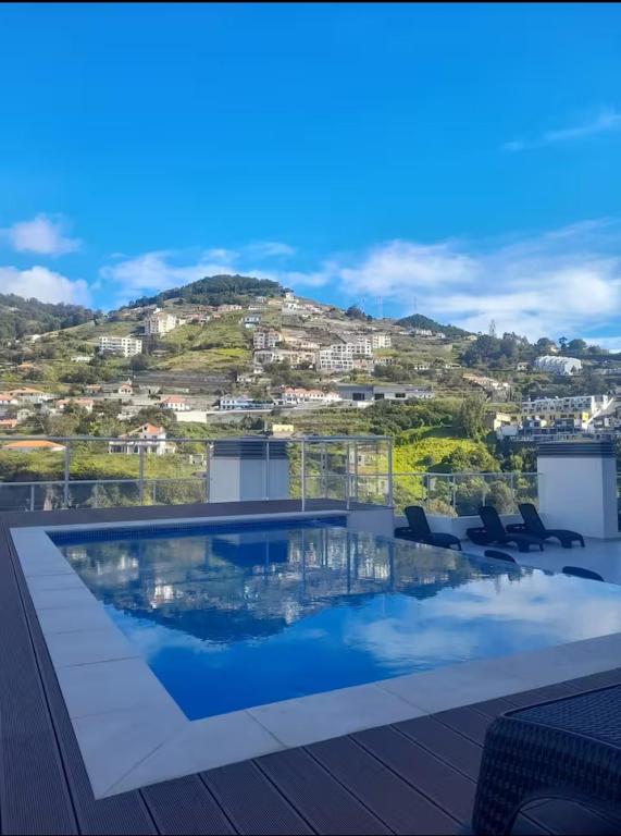 a swimming pool on top of a building with a mountain at Art House Madeira II in Caniço