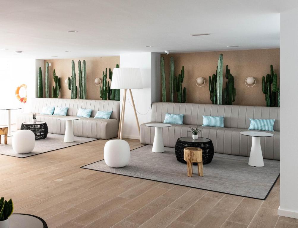 a living room with couches and tables and cactus at BLUESEA Mediodia in El Arenal