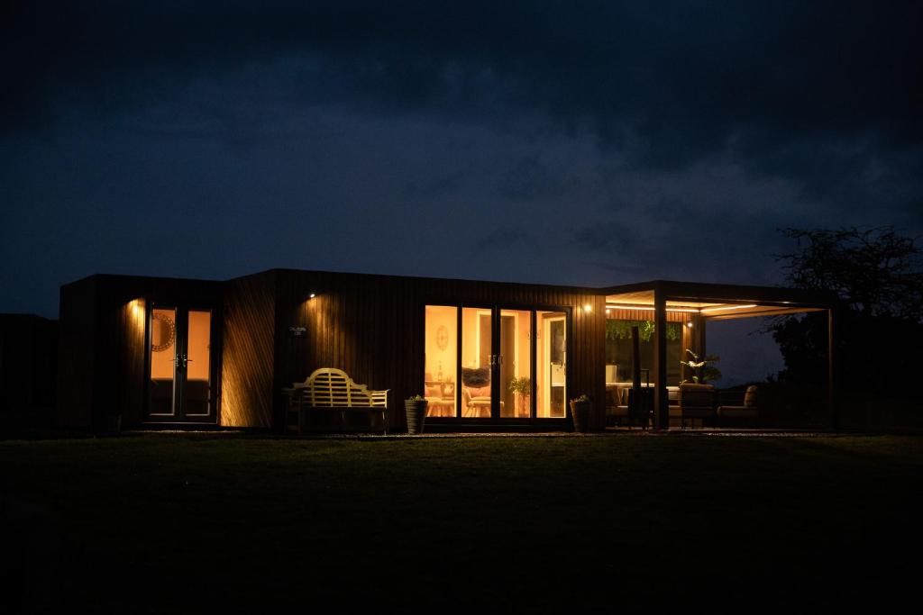 a small house lit up at night at Wigtown by Wigwam Holidays in Newton Stewart