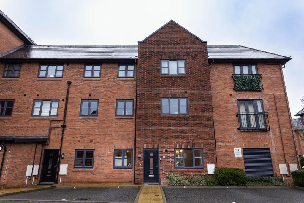 a red brick building with a black door at Hook Three Bed Flat Parking in Hook