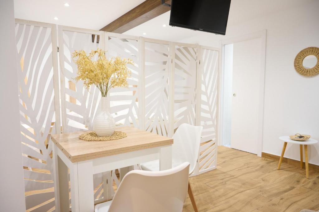 a dining room with a white table and white chairs at La Maestra Catedral 1 in Jaén