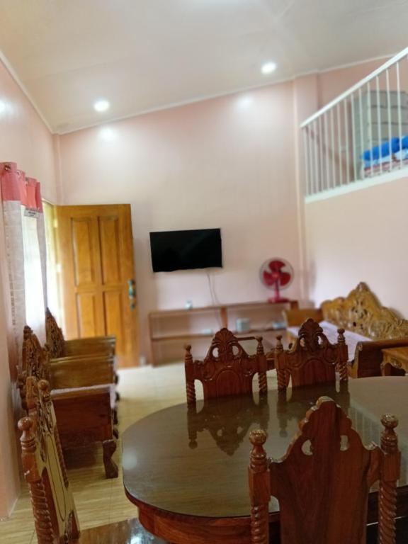 a living room with a table and chairs and a television at cavinitan transient house in Virac