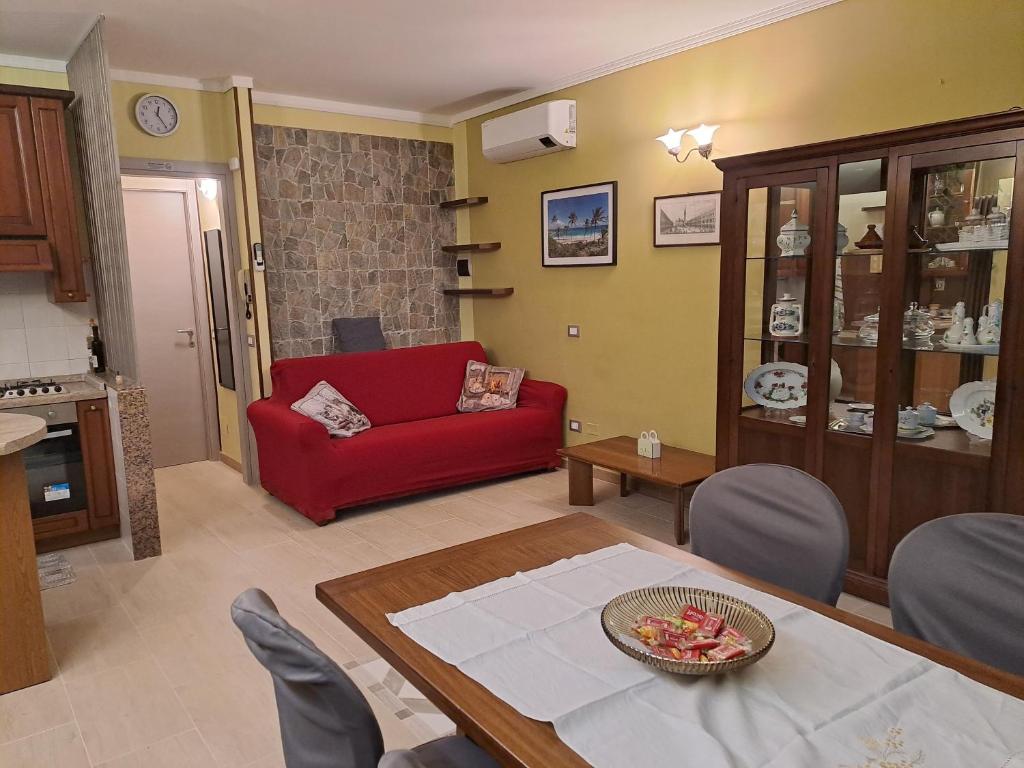 a living room with a red couch and a table at Vista Garda, Casa Vacanze in Roe