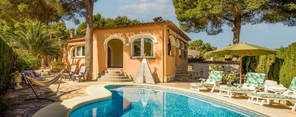 a house with a swimming pool in front of a house at LA VILLA MEDITERRANEA DE HERACLES en Denia in Denia