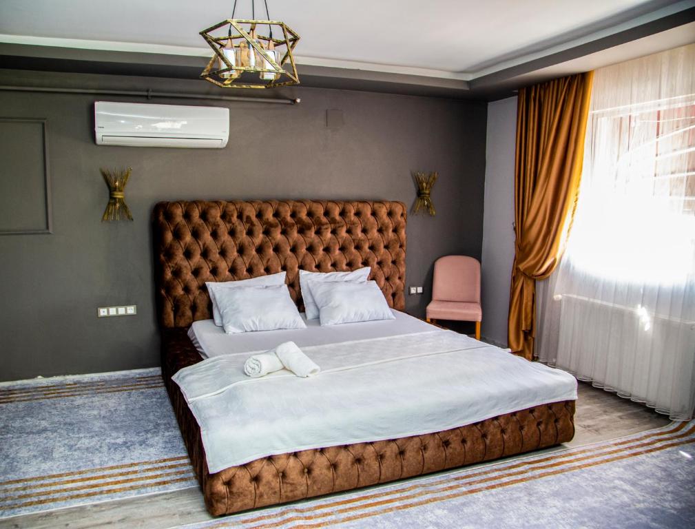 a bedroom with a large bed and a large window at We Nirvana Otel in Mezitli