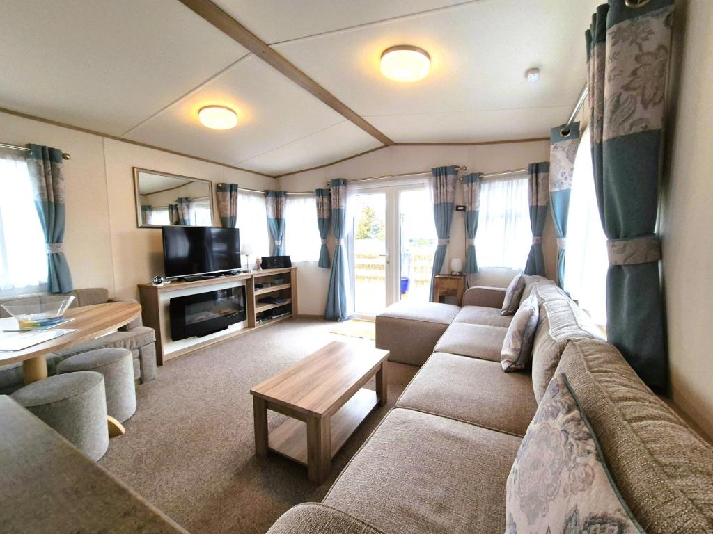 a living room with a couch and a table at Dornoch Holiday Chalet in Proncy