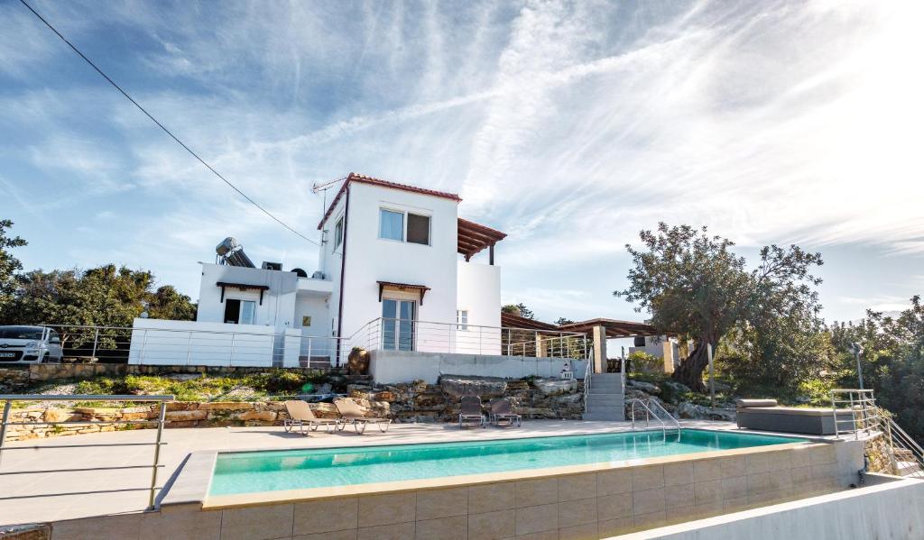 a villa with a swimming pool in front of a house at Villa Sofia Almyrida in Almyrida