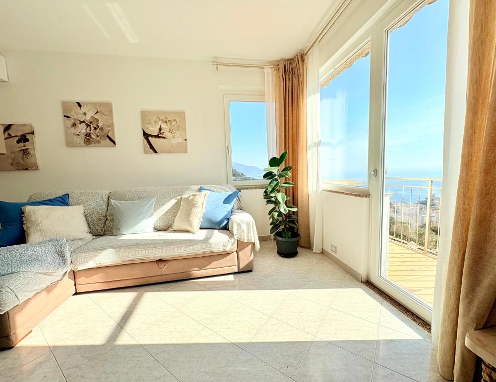 a living room with a couch and a large window at Sunrise apartament in Monterosso al Mare