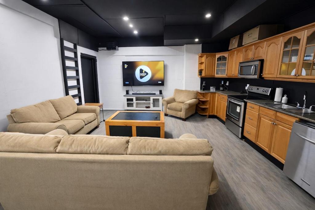 a living room with a couch and a tv in a kitchen at Private Suite, King Bed, Big Screen Sleeps 4 in Hamilton