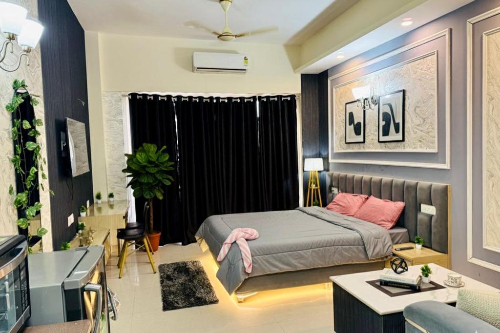 a bedroom with a bed and a living room at Mansion Grey Studio in Ghaziabad
