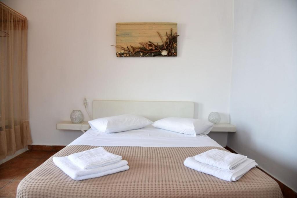 a bedroom with a bed with two towels on it at Anna Rooms Kythnos in Kanala
