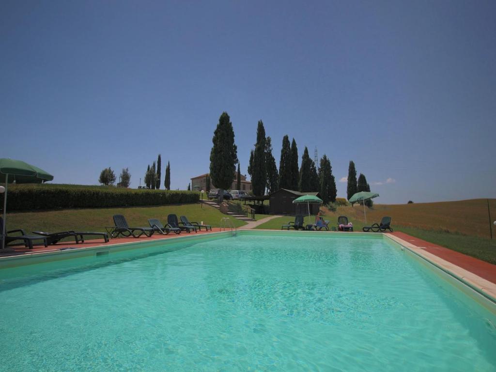 カセッタにあるLarge farmhouse in Tuscany with garden and poolの大型スイミングプール(椅子、パラソル付)