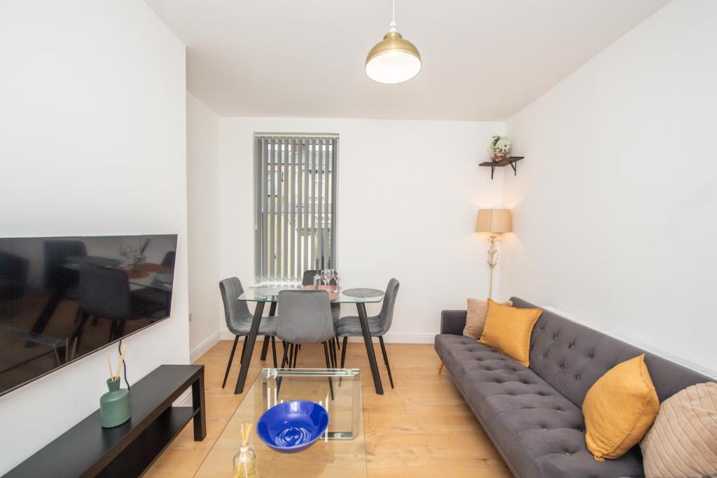 a living room with a couch and a table at Modern 4 Bedroom House Sleeps 10 Free Parking Liverpool in Litherland
